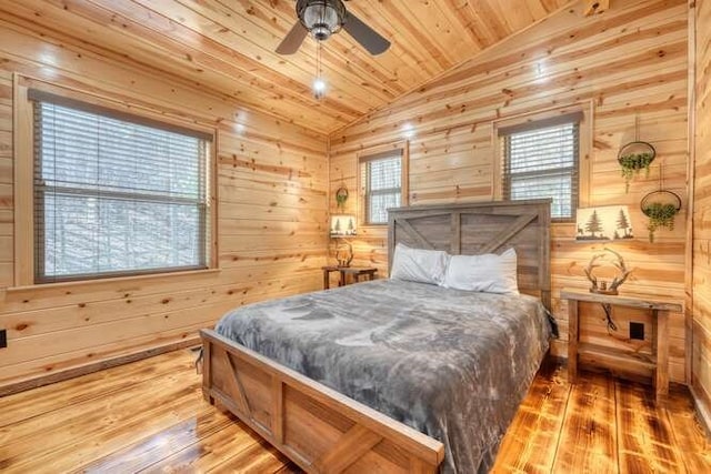 bedroom featuring hardwood / wood-style flooring, vaulted ceiling, wood walls, wooden ceiling, and multiple windows