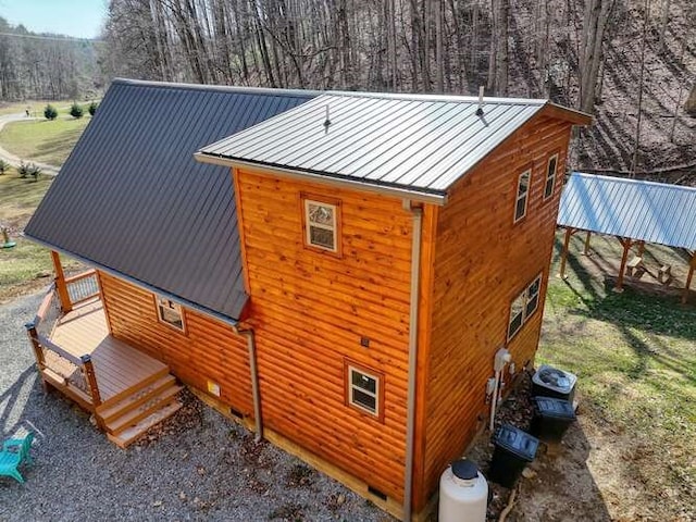 view of property exterior with crawl space, central air condition unit, and metal roof