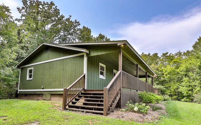 view of side of property with a lawn and a porch