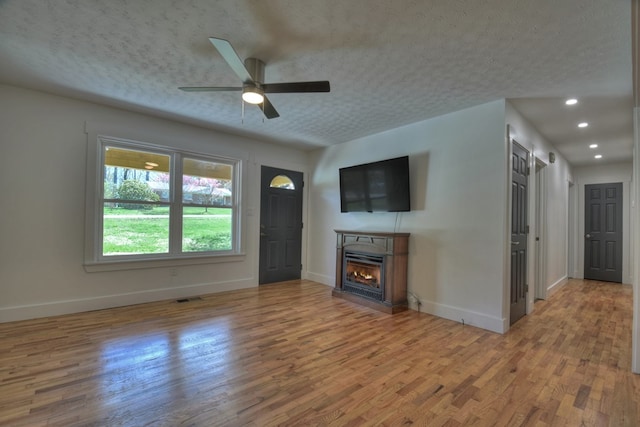 975 Goss Rd, Epworth, GA 30541 - unfurnished living room with baseboards, wood finished floors, ceiling fan, a lit fireplace, and recessed lighting