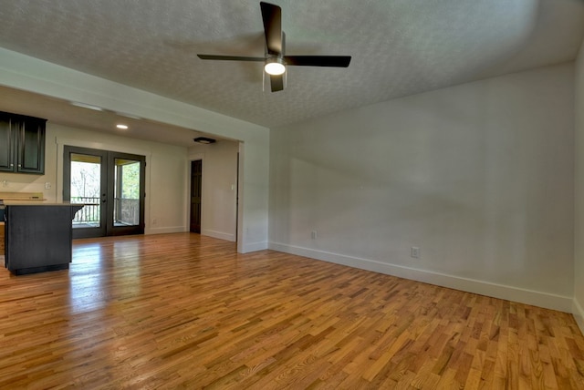 975 Goss Rd, Epworth, GA 30541 - unfurnished living room featuring light wood-type flooring, a textured ceiling, ceiling fan, and baseboards