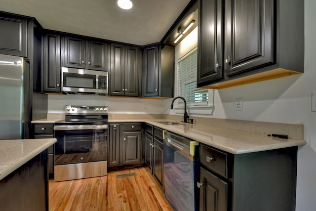 975 Goss Rd, Epworth, GA 30541 - kitchen featuring appliances with stainless steel finishes, a sink, light wood finished floors, and light stone counters
