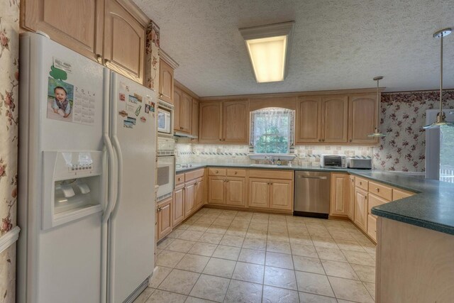 kitchen featuring stainless steel appliances, sink, hanging light fixtures, light tile patterned floors, and decorative backsplash