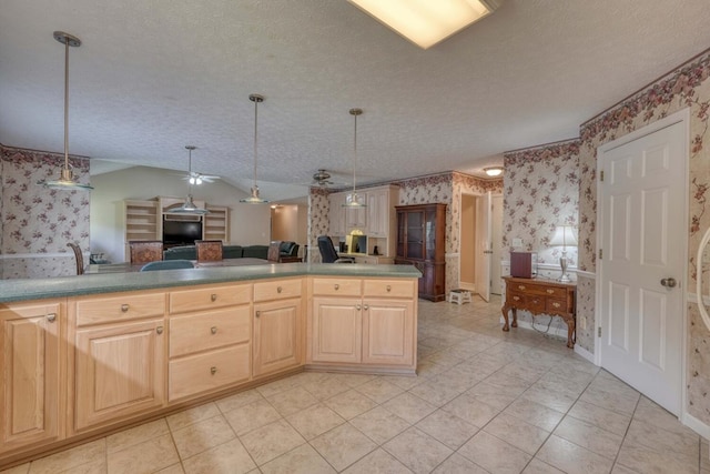 kitchen with light brown cabinetry, a textured ceiling, and light tile patterned floors