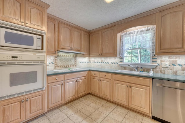 kitchen with sink, tasteful backsplash, light tile patterned floors, and white appliances