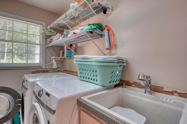 laundry room featuring washing machine and dryer, sink, and a textured ceiling