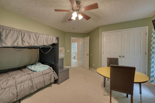 carpeted bedroom featuring a closet, a textured ceiling, and ceiling fan