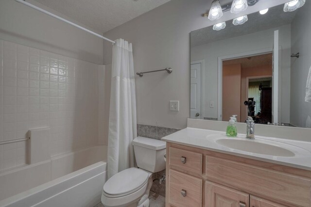 full bathroom with vanity, a textured ceiling, toilet, and shower / tub combo