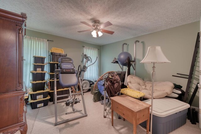 bedroom featuring ceiling fan, light carpet, and a textured ceiling