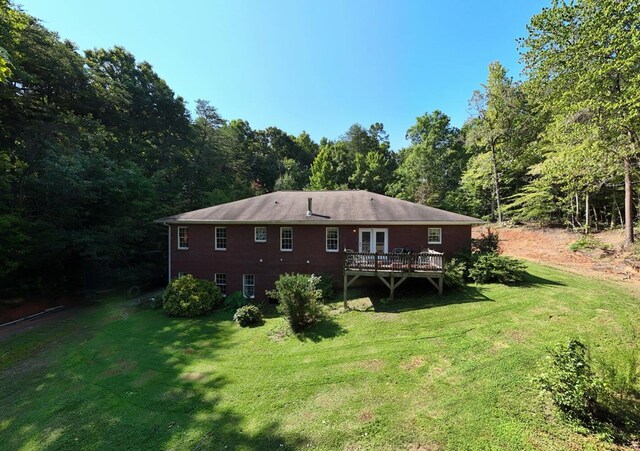 back of property featuring a deck and a yard