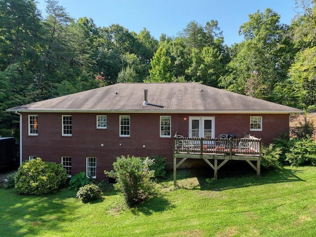 rear view of house with a deck and a lawn