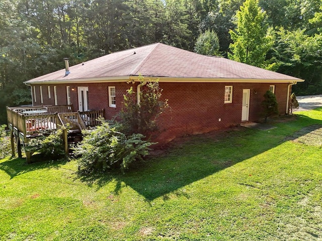 exterior space with a wooden deck and a lawn