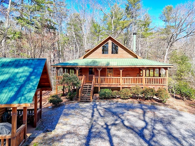 view of front of house with a porch, stairway, and metal roof