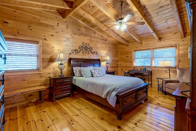 bedroom with vaulted ceiling with beams, wood walls, wood ceiling, a ceiling fan, and light wood-type flooring