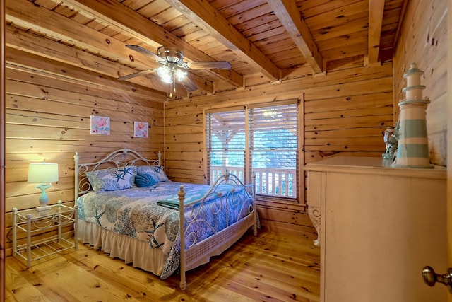 bedroom with wooden ceiling, wood walls, and beam ceiling