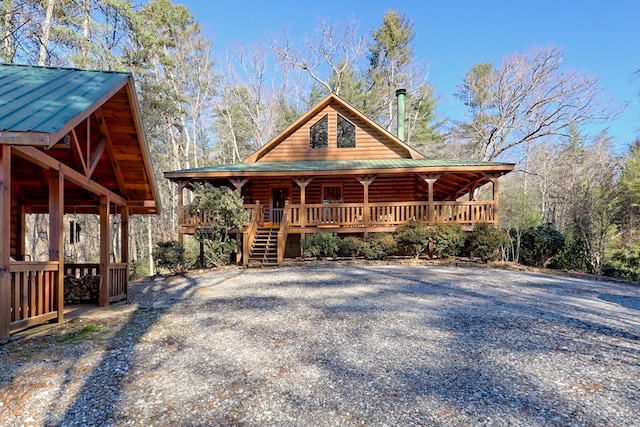 exterior space featuring a porch, stairway, and metal roof