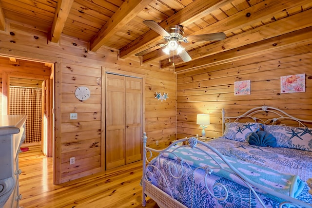 bedroom featuring light wood-type flooring, wood ceiling, beamed ceiling, and wood walls