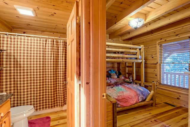 bedroom with wooden ceiling, wooden walls, light wood finished floors, and beam ceiling