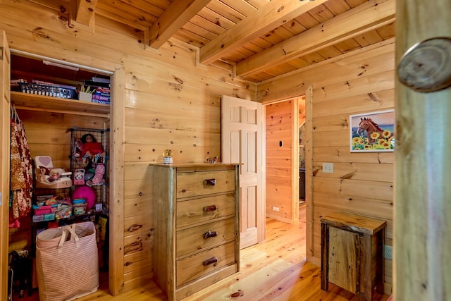 interior space with beam ceiling, wooden ceiling, wood walls, and light wood-style flooring