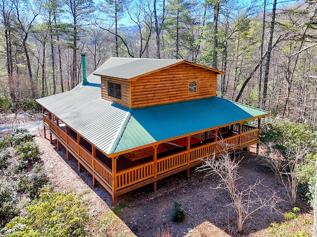 view of front of house with log veneer siding and metal roof