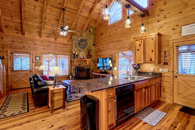 kitchen with light wood-style floors, wood ceiling, wooden walls, a stone fireplace, and beamed ceiling