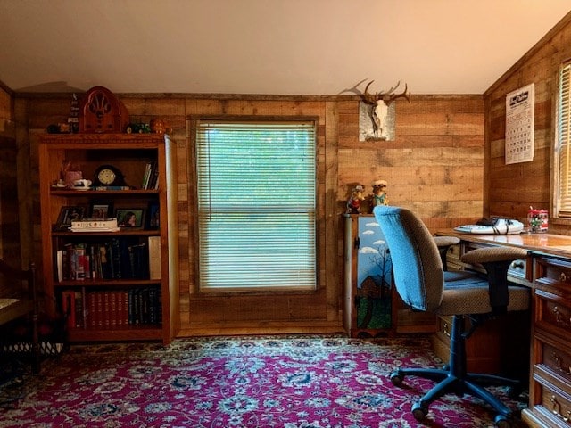home office with lofted ceiling and wood walls