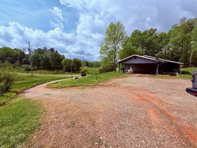 exterior space with a lawn, driveway, and an attached carport