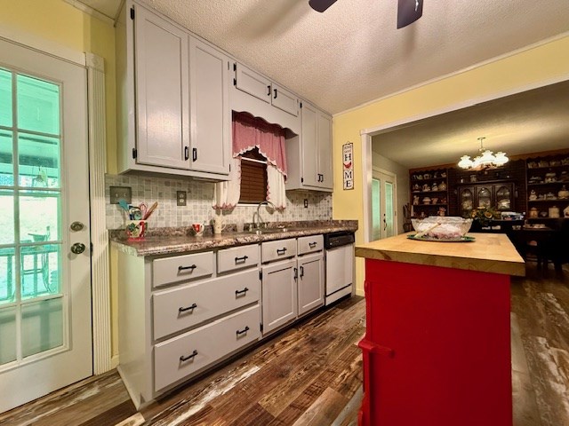 kitchen featuring backsplash, dishwashing machine, ceiling fan with notable chandelier, and butcher block countertops