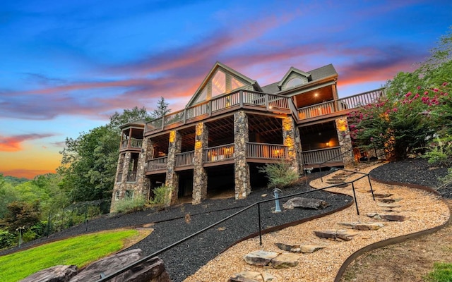 back house at dusk with a balcony