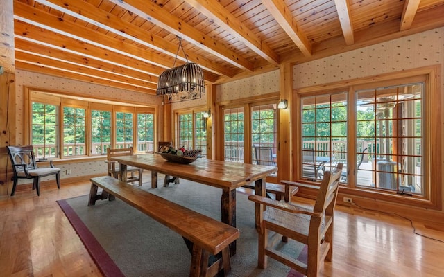 dining area with light hardwood / wood-style flooring, wood ceiling, and plenty of natural light