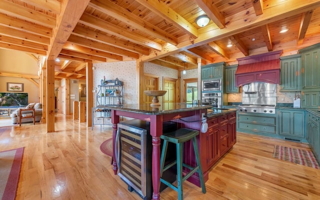 kitchen featuring a center island, backsplash, stainless steel appliances, a kitchen bar, and light hardwood / wood-style floors