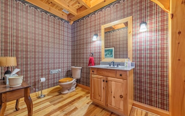 bathroom featuring toilet, wood ceiling, beamed ceiling, vanity, and hardwood / wood-style flooring