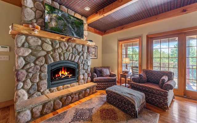 living room with wooden ceiling, a fireplace, light hardwood / wood-style flooring, and beam ceiling