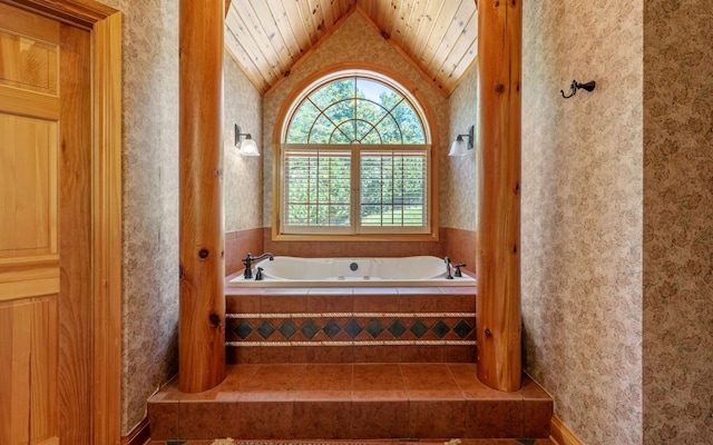 bathroom featuring a relaxing tiled bath and vaulted ceiling