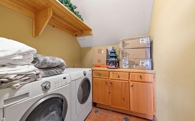 washroom featuring washing machine and clothes dryer, cabinets, and light tile flooring