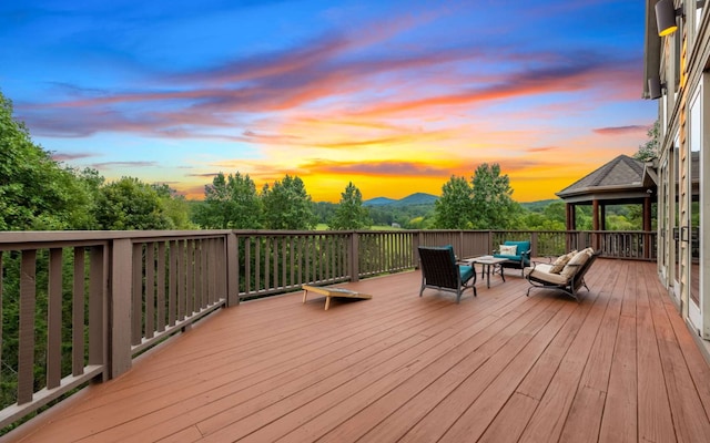 deck at dusk featuring an outdoor living space