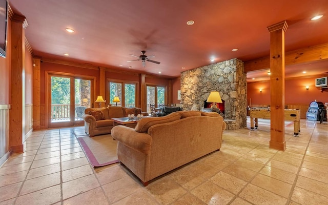 living room featuring plenty of natural light, ceiling fan, light tile floors, and a fireplace