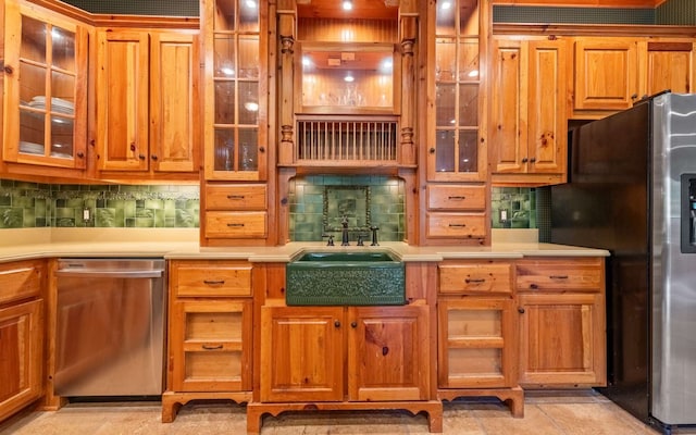 kitchen featuring appliances with stainless steel finishes, sink, tasteful backsplash, and light tile floors