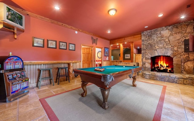 recreation room with pool table, ornamental molding, light tile floors, and a fireplace