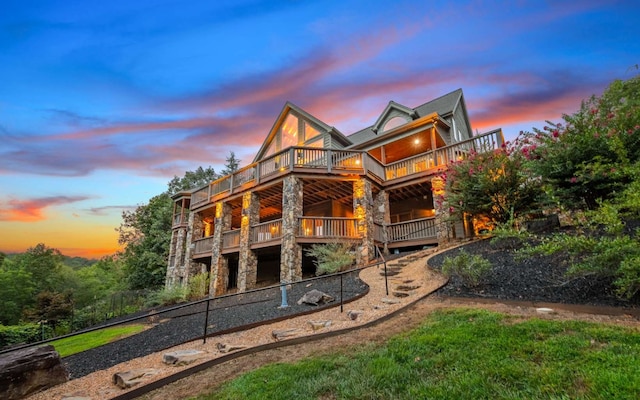 back house at dusk featuring a balcony