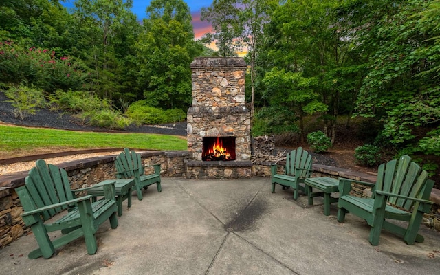 patio terrace at dusk with an outdoor stone fireplace