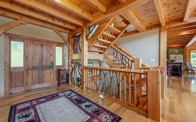 foyer entrance featuring beam ceiling, wooden ceiling, and light hardwood / wood-style flooring