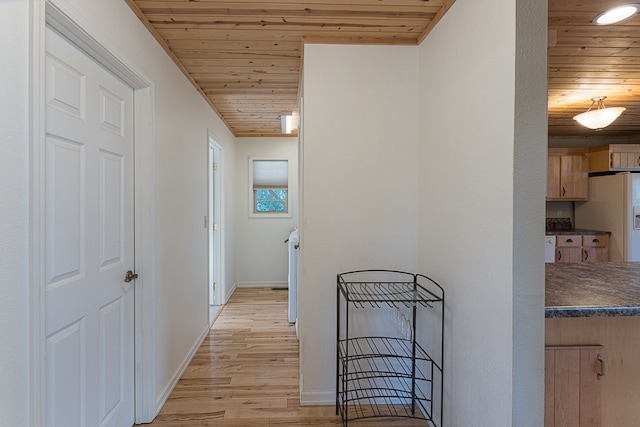 hall with light hardwood / wood-style flooring and wooden ceiling