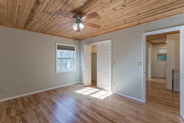 unfurnished bedroom with ceiling fan, light hardwood / wood-style floors, a closet, and wooden ceiling