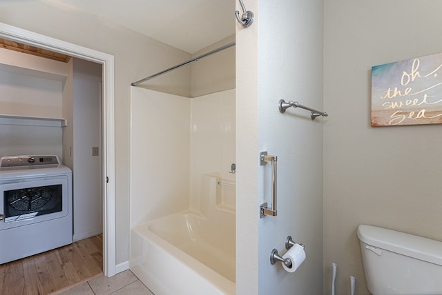 bathroom with tile patterned flooring, washer / dryer, and toilet