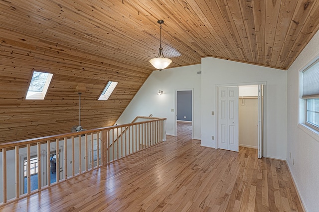 interior space featuring a skylight, high vaulted ceiling, light hardwood / wood-style flooring, and wooden ceiling