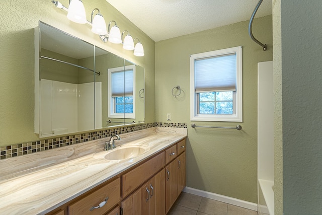 bathroom with  shower combination, a textured ceiling, vanity, tile patterned flooring, and decorative backsplash