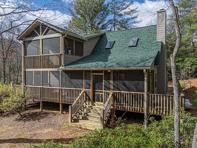 rear view of property featuring a sunroom