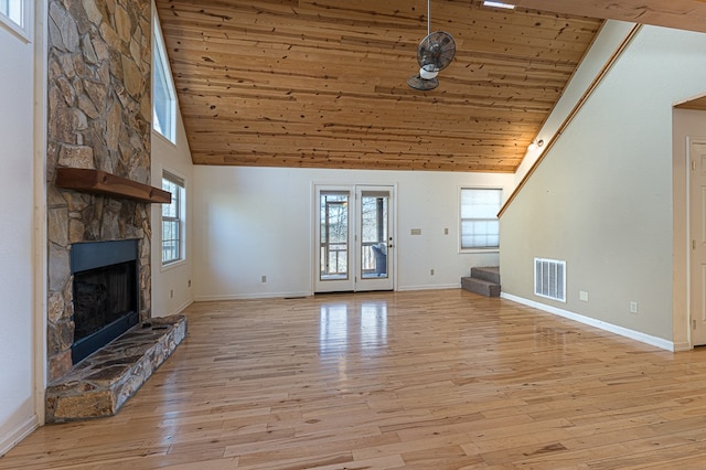 unfurnished living room with a wealth of natural light, high vaulted ceiling, a fireplace, wood ceiling, and light hardwood / wood-style floors