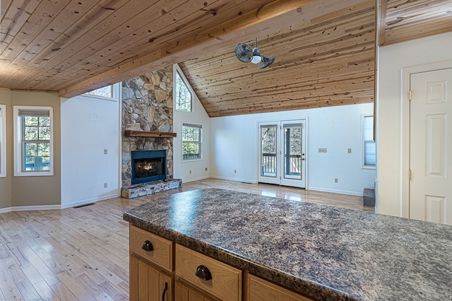 unfurnished living room with a healthy amount of sunlight, wooden ceiling, and light hardwood / wood-style flooring